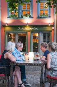 萨勒河畔瑙姆堡Schulmeisterhaus的一群坐在桌子上戴酒杯的女人