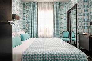 巴黎梦索爱丽舍酒店的一间卧室配有一张床和两张蓝色椅子