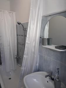 陶波尔曹Sport Apartman Tapolca的浴室配有盥洗盆和带镜子的淋浴