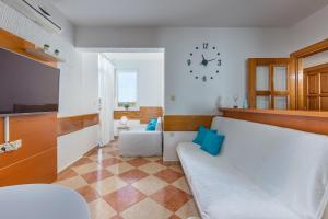 德拉马利Villa Oleander的客厅配有沙发和墙上的时钟