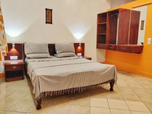 蒙巴萨Marigold Guest House的一间卧室配有一张带橙色墙壁的大床