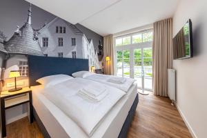 布隆Lake House Plön的一间卧室设有一张大床和一个大窗户