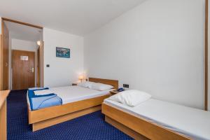 诺瓦利娅the Loža - seaside festival hotel的一间卧室设有两张床,一扇门通往房间