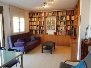 阿尔么丽亚Atico Alhamilla的客厅配有沙发和书架,书架上装满了书籍