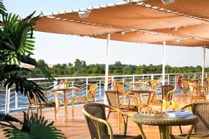 卢克索Jaz Crown Jubilee Nile Cruise - Every Thursday from Luxor for 07 & 04 Nights - Every MondayFrom Aswan for 03 Nights的游轮上带桌椅的甲板