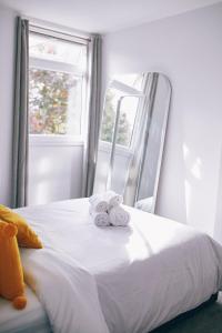 伦敦Authentic Battersea Experience的一张带两条毛巾的床和窗户