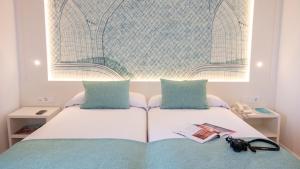 皮内达德马尔Golden Taurus Aquapark Resort的一张带两个枕头的白色床和一本书