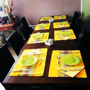 卡洛福泰Charming Rooms Opuntia的长桌,带黄色餐巾,叉子和刀