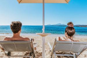 阿尔巴塔克斯Hotel Club Saraceno - Bovis Hotels的坐在沙滩椅上的男人和女人