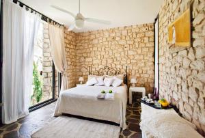 莫迪卡Stone House Modica的一间卧室设有一张床和石墙