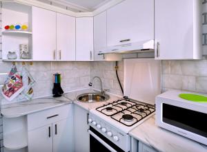 久姆里KAYARAN home的白色的厨房配有炉灶和水槽