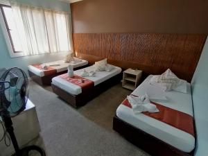 卡利博RB Bed and Breakfast的酒店客房设有三张床和风扇。