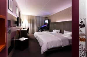 威斯巴登pentahotel Wiesbaden的酒店客房设有一张大床和一台电视。