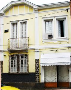 里约热内卢Estúdios Deluxe São Manuel的黄色的建筑,设有两扇窗户和阳台