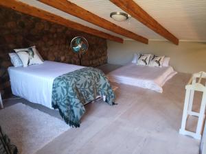 内尔斯普雷特Arend Cottage的配有木天花板的客房设有两张床。