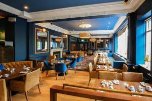 都柏林布斯特尔斯敦格里森斯联排别墅酒店的餐厅设有木桌和椅子,拥有蓝色的墙壁