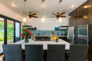 西区Vivaro Roatan Beachfront的厨房配有桌椅和吊扇