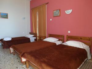 卡拉马塔亚历山大酒店的红色墙壁客房的两张床