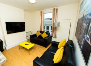 德比The Stay Company, Derby Central的客厅配有黑色沙发和黄色枕头