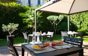 米兰圣法兰西丝科酒店的一张桌子,上面有两盘食物和一把伞