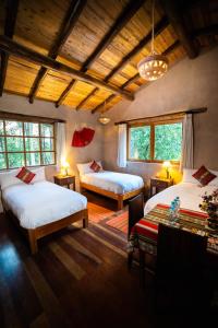 乌鲁班巴神圣梦想小屋酒店的一间卧室配有两张床和一张桌子。