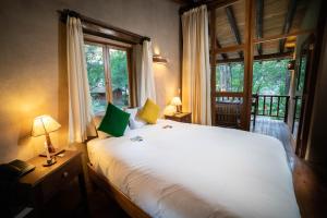 乌鲁班巴神圣梦想小屋酒店的卧室设有一张白色大床和一扇窗户。