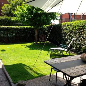 马里纳·迪·比萨Casa del Sole - Sunshine Home的一个带桌椅和遮阳伞的庭院