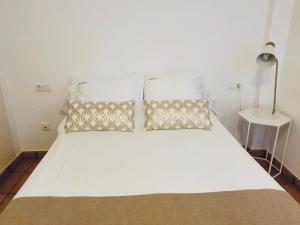 卡达克斯Mimoses Apartaments的一张白色的床,上面有两个枕头