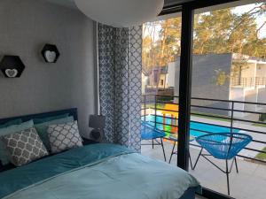 波别罗沃Apartament Scandi N*.9的一间卧室设有一张床,阳台设有游泳池