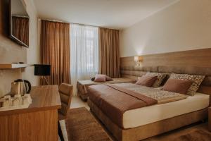 武科瓦尔Villa Martini - apartments & rooms的酒店客房配有两张床和一张书桌