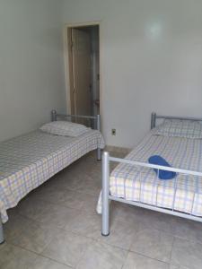 ItaberabaPousada Casarrara的两张睡床彼此相邻,位于一个房间里