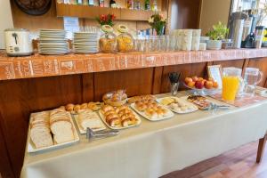 圣卡洛斯-德巴里洛切拉帕斯托瑞拉宾馆的一张桌子,上面放着各种面包和糕点