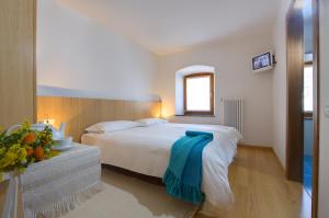Treppo CarnicoAlbergo Cristofoli的一间卧室配有一张带蓝色毛巾的床