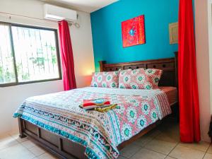 科克Studio Apartments in Las Torres的一间卧室配有一张蓝色墙壁和红色窗帘的床