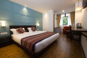 甘托克Bumblebee Bed & Breakfast的酒店客房设有一张大床和一张书桌。
