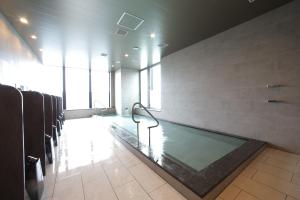 福冈Miyako Hotel Hakata的一间大浴室,在房间内设有一个游泳池