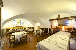 Treppo CarnicoAlbergo Cristofoli的餐厅配有桌椅和白色的桌布