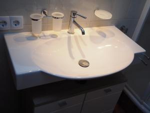 弗利斯Haus Gabriel的浴室里的一个白色水槽,上面有两杯