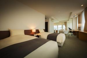 函馆康考迪亚别墅Spa度假酒店的酒店客房配有两张床和一张书桌