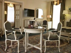 玛丽亚温泉滨海温泉高尔夫度假酒店的客厅配有桌椅和电视。