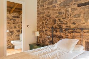 卡瓦尼亚斯Villa Valedoso的石墙房间内的一张床位