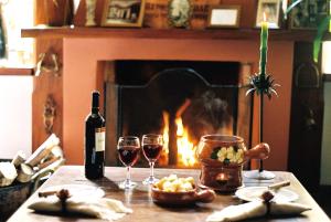 帕萨夸特鲁帕萨达圣拉斐尔旅馆的一张桌子,配有两杯葡萄酒和一个壁炉