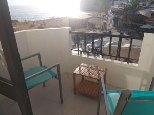 卡武埃鲁Apartamento na Praia的一个带桌椅的阳台和一个海滩