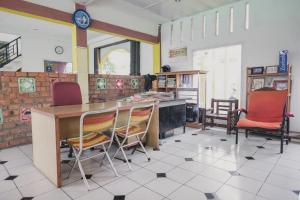 占碑市RedDoorz Syariah @ Pasir Putih Jambi的厨房配有桌椅和时钟
