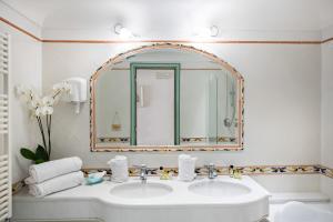波西塔诺爱赛昂公寓式酒店的一间带水槽和镜子的浴室