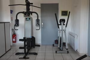 瓦尔拉普拉日Hotel Albizzia的健身房,室内有3辆健身自行车