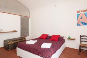 普拉托Appartamento 123的一间卧室配有红色枕头的床