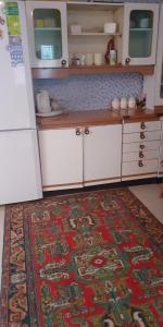 久姆里Guest House OTILIA的厨房配有白色橱柜和地板上的地毯
