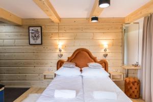 考斯赛力克udanypobyt Apartamenty Przy Dolinach C i D的一间卧室设有木墙和一张带两个枕头的床
