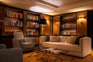 波尔图Maison Albar - Le Monumental Palace的客厅配有沙发、椅子和书架